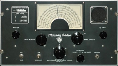 Gray tabletop receiver with a semi-circular dial and 6 knobs